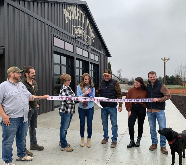 Casey Port ’16, ’19 M.B.A., center, cuts the ribbon with her family at the grand opening of Poverty Knob Farmhouse Ales in November.